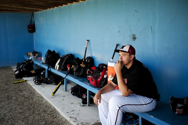 Milan High School junior James Carpenter sits in the dugout by himself before the game against Richmond in Battle Creek on Friday, June 14. Daniel Brenner I AnnArbor.com